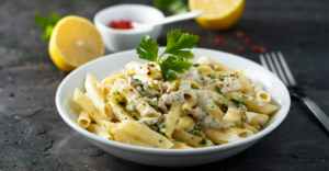 Delicious homemade white sauce pasta with creamy texture, loaded with bell peppers, capsicum, broccoli, and sweet corn, garnished with fresh coriander. A perfect Italian-style pasta recipe for a rich and flavorful meal.